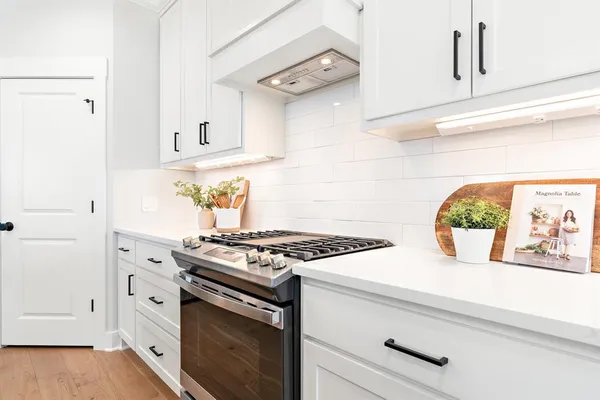 a white stove top oven sitting inside of a kitchen