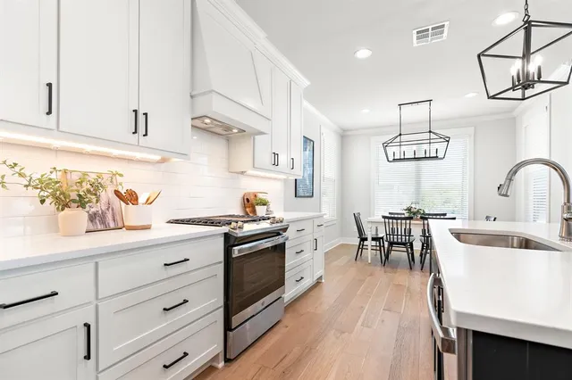a kitchen with granite countertop a sink a stove and cabinets