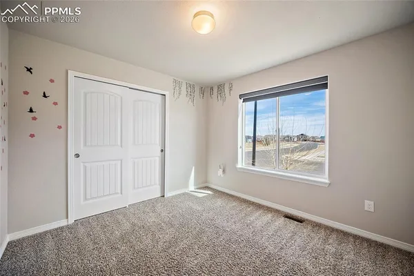 an empty room with windows and closet