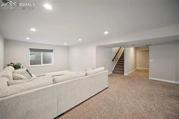 a living room with furniture and stairs