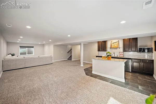 a kitchen with granite countertop cabinets and wooden floor