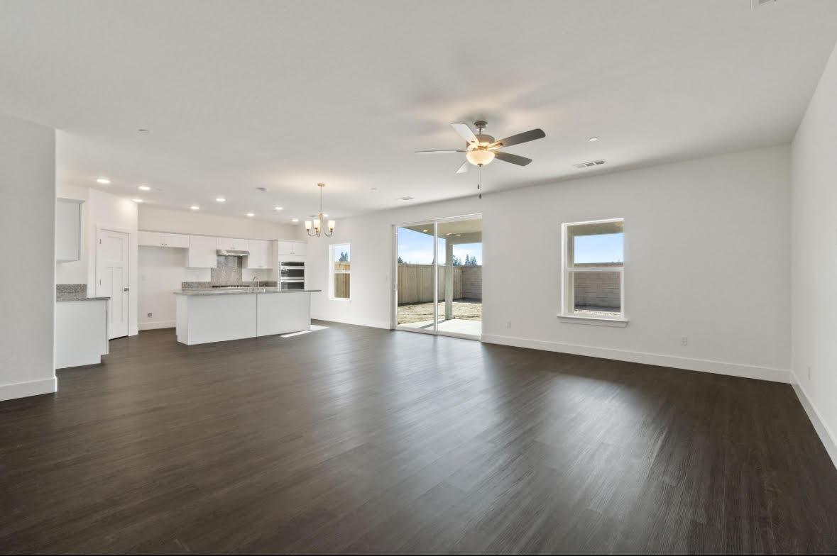 1207 Via Valencia Madera, CA 93637 - Photo 2 of 10 a view of an empty room with wooden floor and a kitchen