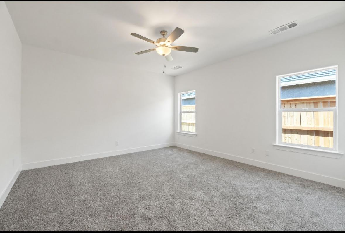 1207 Via Valencia Madera, CA 93637 - Photo 8 of 10 an empty room with windows and fan