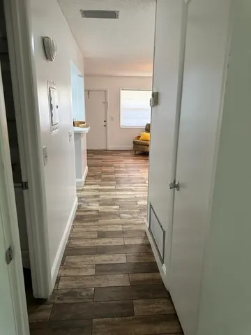 a view of a hallway with wooden floor and staircase