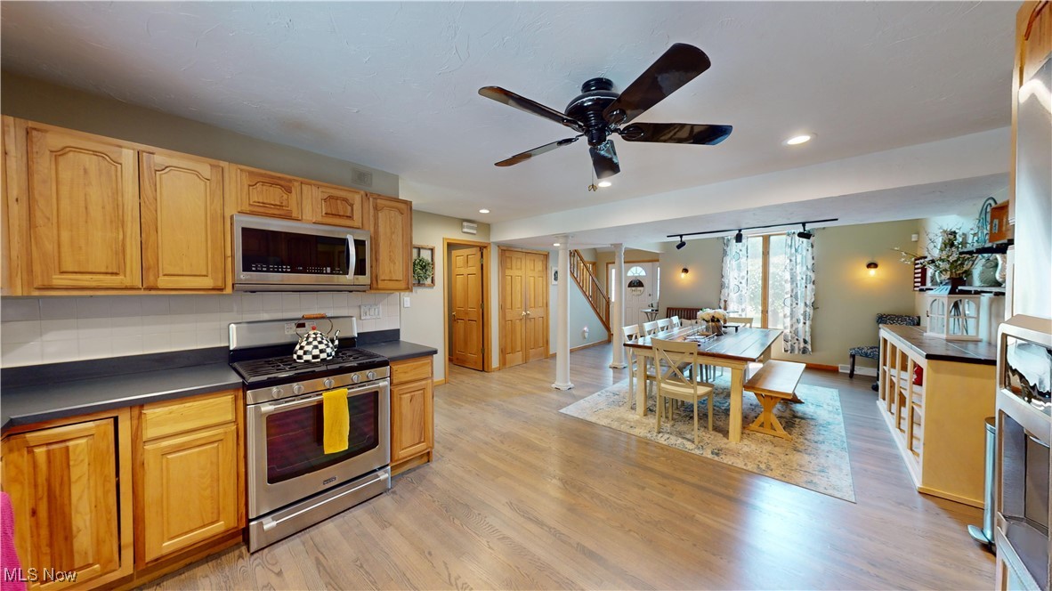 571 Ledge Road Macedonia, OH 44056 - Photo 11 of 35 Kitchen with decorative backsplash, appliances with stainless steel finishes, light wood-type flooring, and ceiling fan