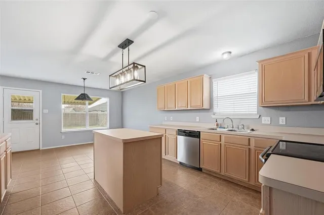 a kitchen with a sink a stove cabinets and wooden floor
