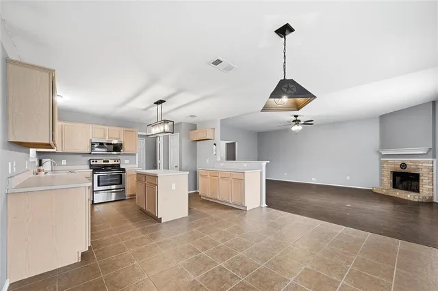 a kitchen with a sink a counter top space stainless steel appliances and cabinets