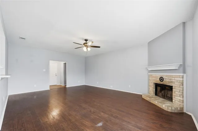 a view of empty room with wooden floor and fireplace