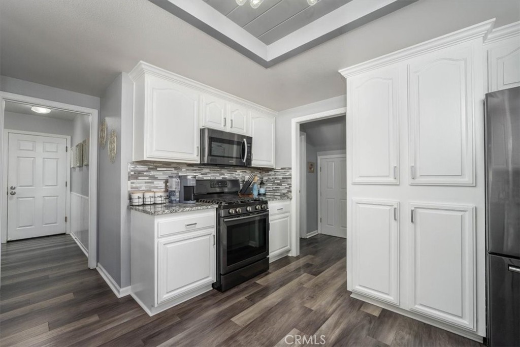 14720 McCoy Road Red Bluff, CA 96080 - Photo 8 of 49 a kitchen with cabinets stainless steel appliances and wooden floor