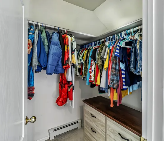 a view of walk in closet with clothes