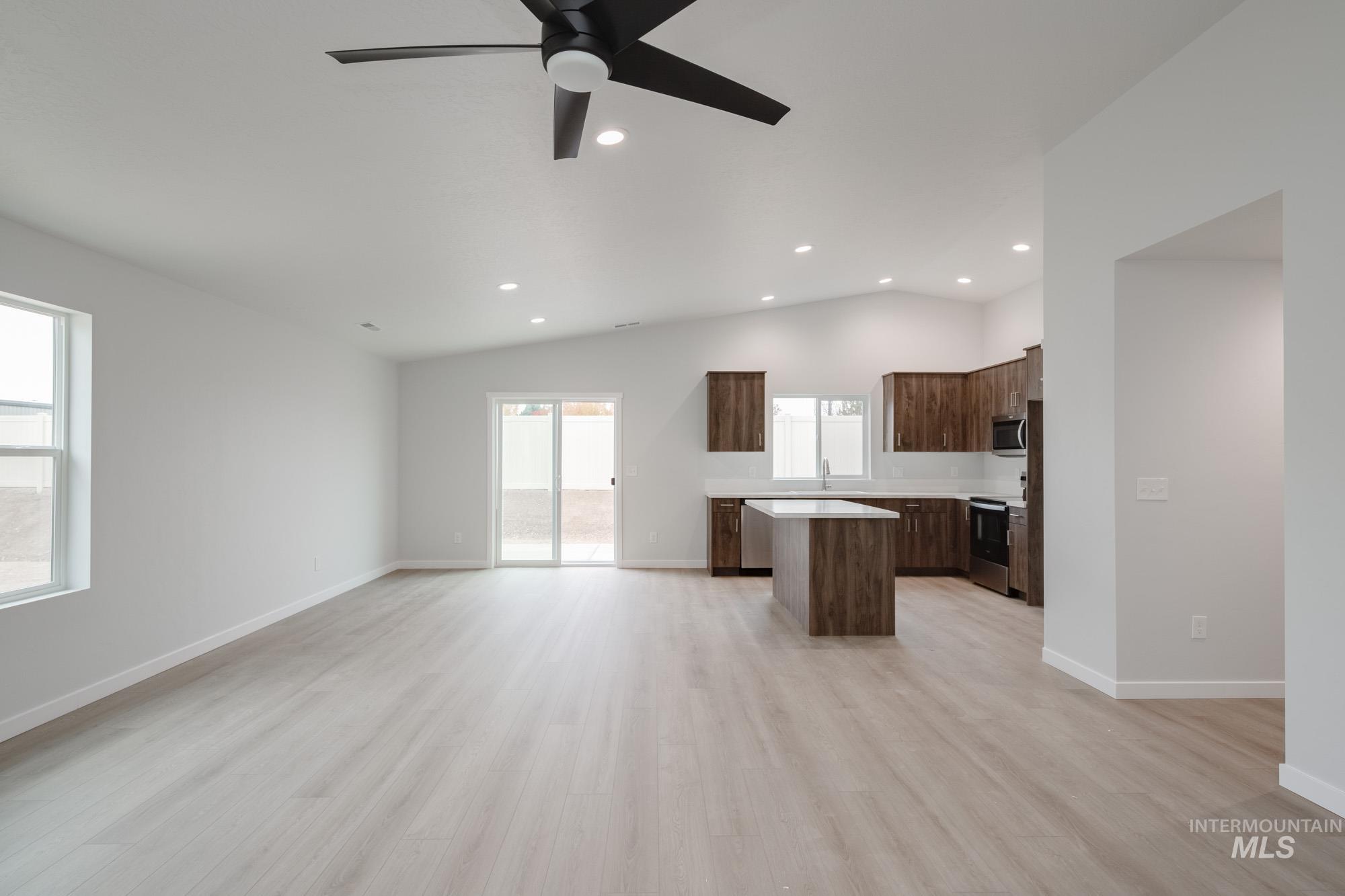 13736 Nisene Street Caldwell, ID 83607 - Photo 21 of 22 Kitchen with a kitchen island, open floor plan, light countertops, light wood-type flooring, and dark brown cabinetry