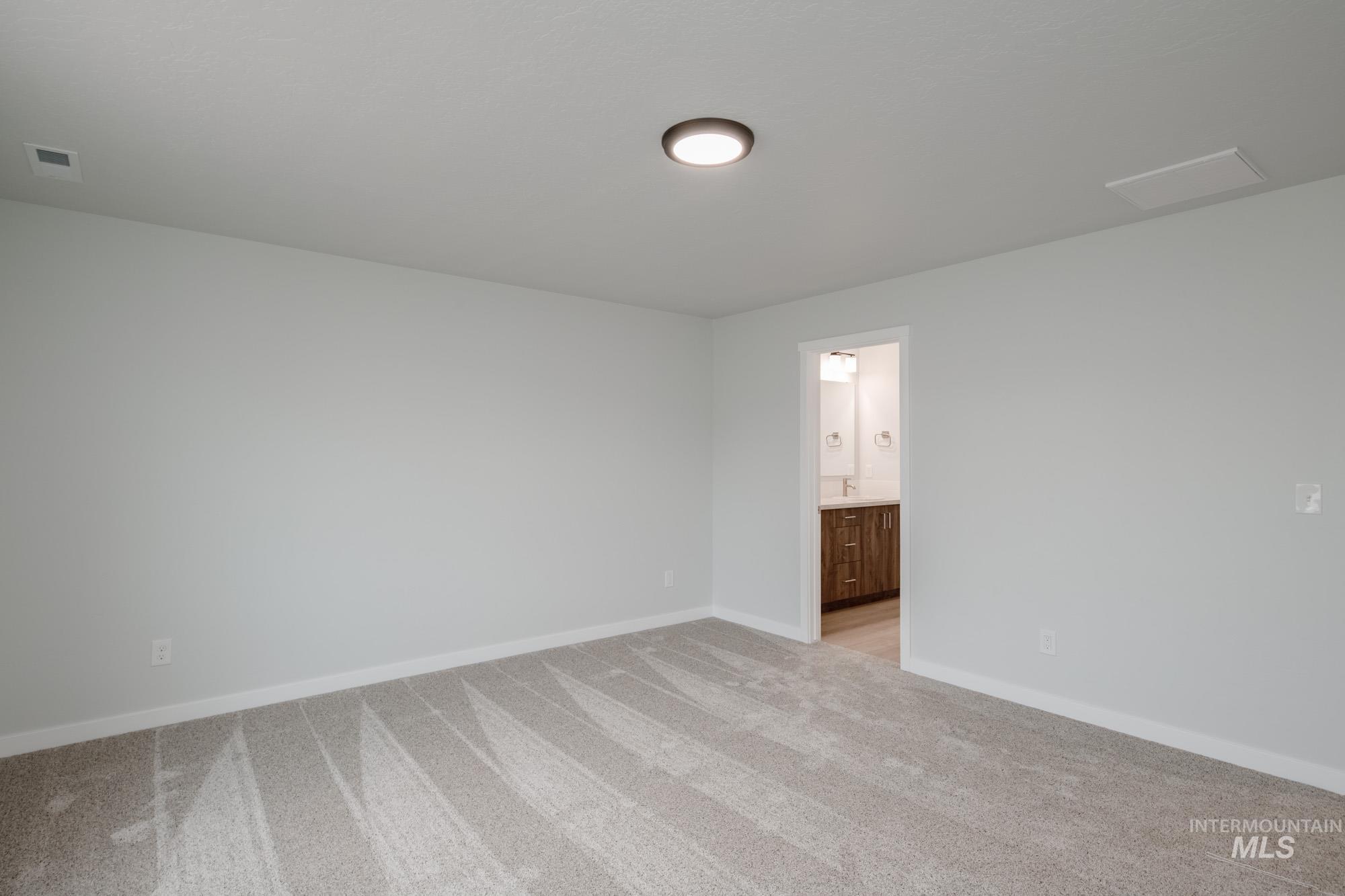 13736 Nisene Street Caldwell, ID 83607 - Photo 18 of 22 Empty room with light colored carpet and baseboards