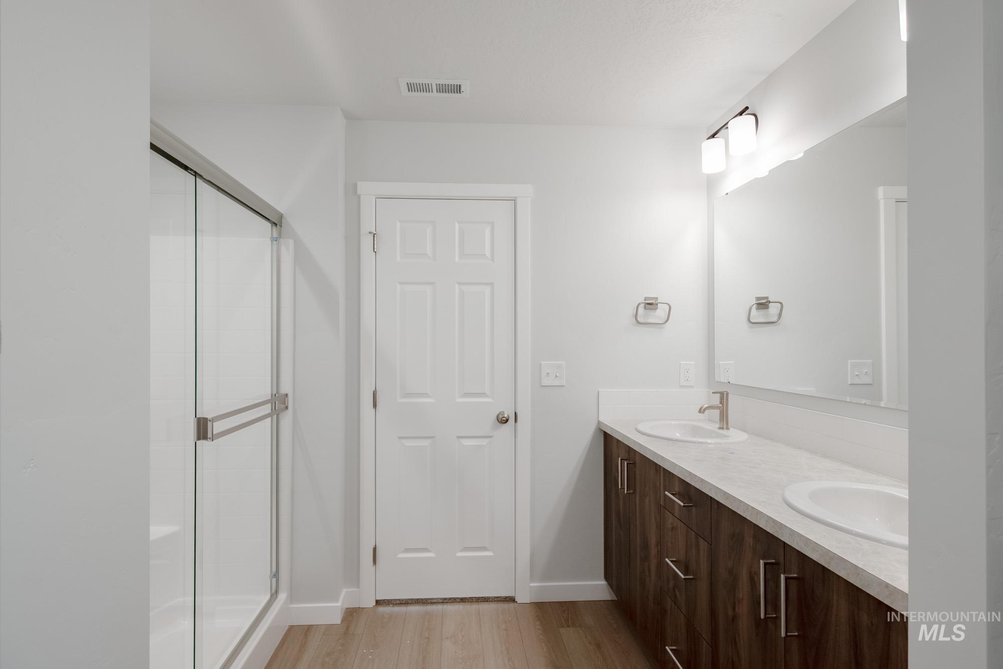 13736 Nisene Street Caldwell, ID 83607 - Photo 20 of 22 Full bath featuring double vanity, light wood finished floors, and a stall shower