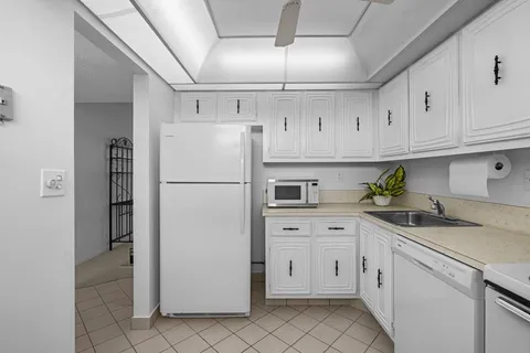 a kitchen with white cabinets and white appliances