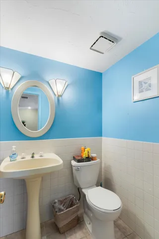 a bathroom with a sink mirror and toilet