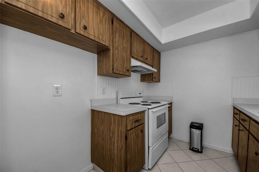 1701 Pinehurst Road, Unit 4F Dunedin, FL 34698 - Photo 18 of 56 a kitchen with stainless steel appliances granite countertop a stove a sink and a refrigerator