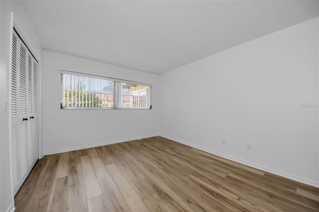 1701 Pinehurst Road, Unit 4F Dunedin, FL 34698 - Photo 27 of 56 an empty room with wooden floor and windows