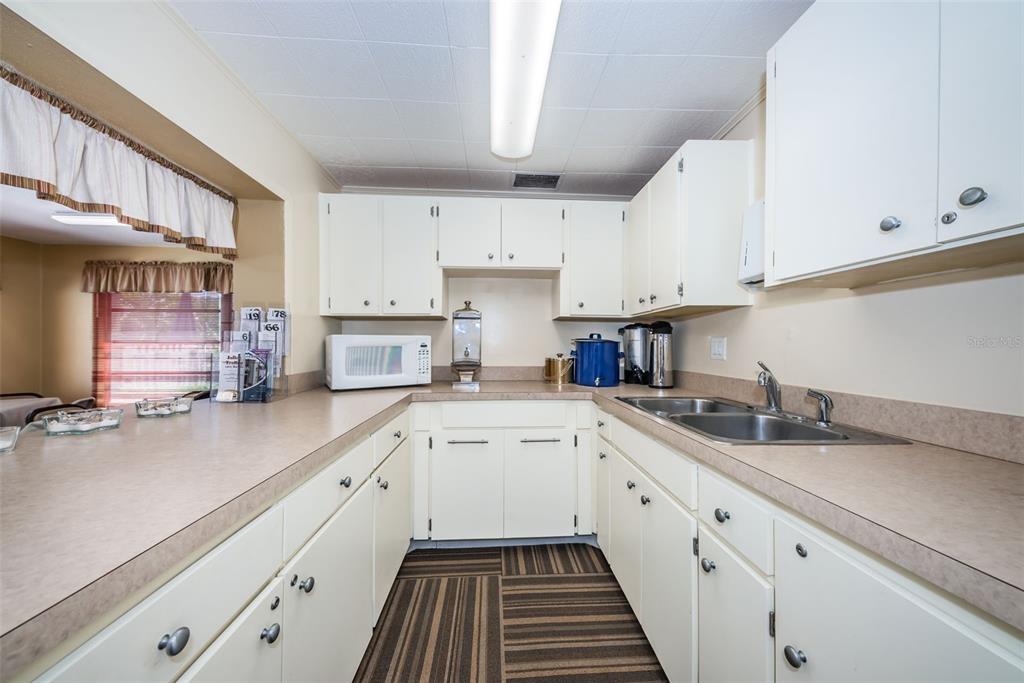 1701 Pinehurst Road, Unit 4F Dunedin, FL 34698 - Photo 42 of 56 a kitchen with a sink dishwasher stove and white cabinets