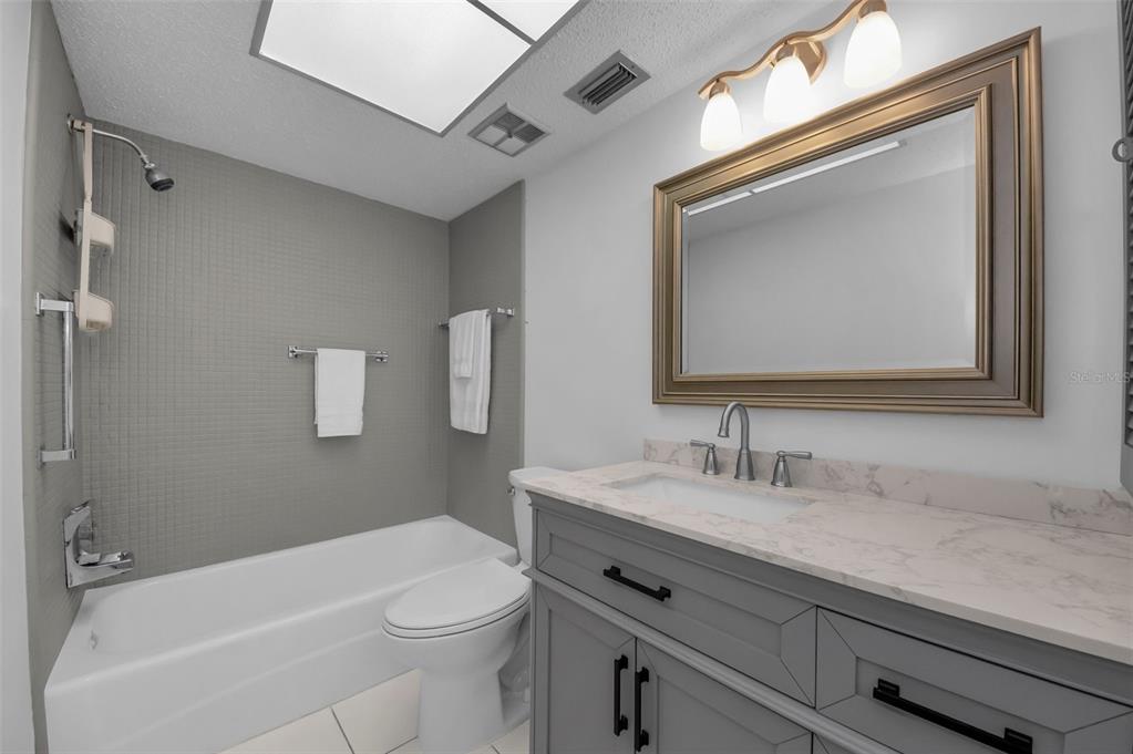 1701 Pinehurst Road, Unit 4F Dunedin, FL 34698 - Photo 7 of 56 a bathroom with a sink a toilet and a mirror