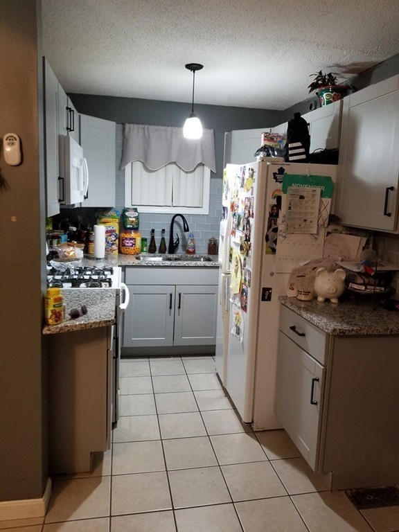 18 Mott Street Fall River, MA 02721 - Photo 3 of 27 a kitchen with stainless steel appliances granite countertop a sink a stove a refrigerator and cabinets