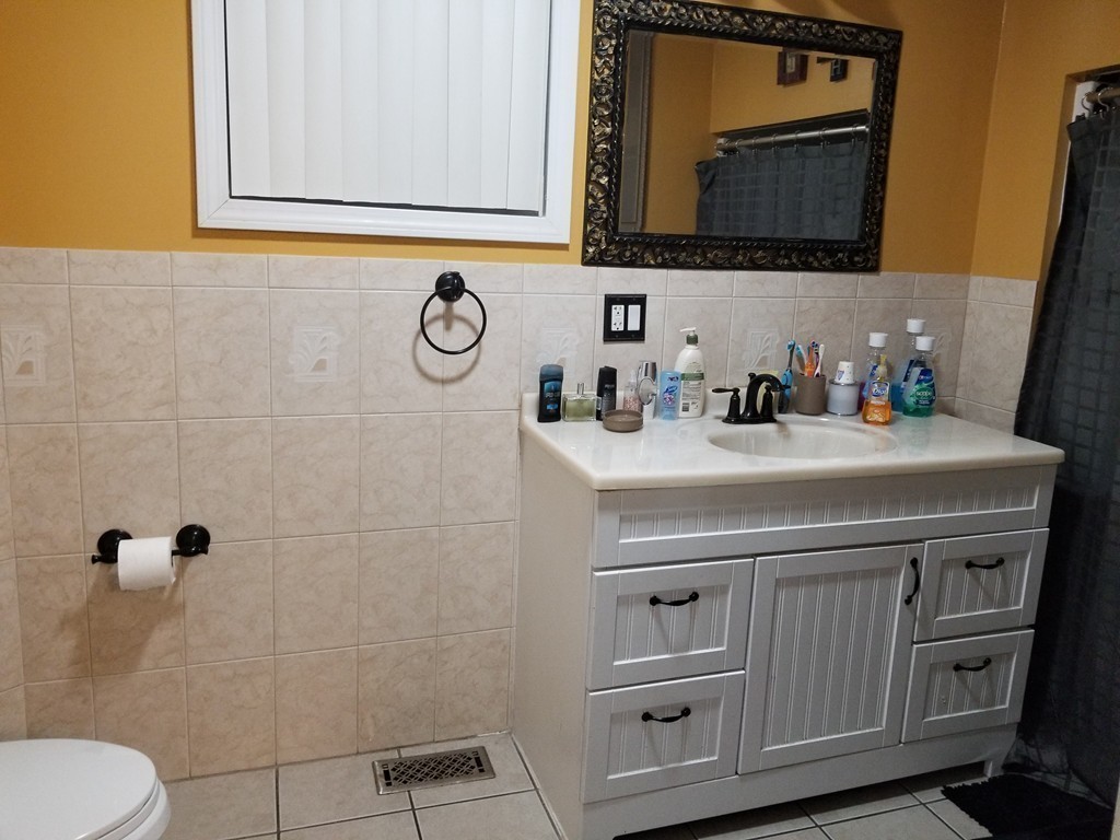 18 Mott Street Fall River, MA 02721 - Photo 4 of 27 a bathroom with a sink a toilet and mirror