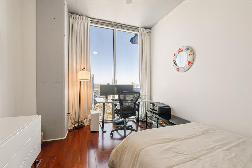 3324 Peachtree Road Northeast, Unit 2705 Atlanta, GA 30326 - Photo 33 of 68 a bedroom with a bed and a table with wooden floor