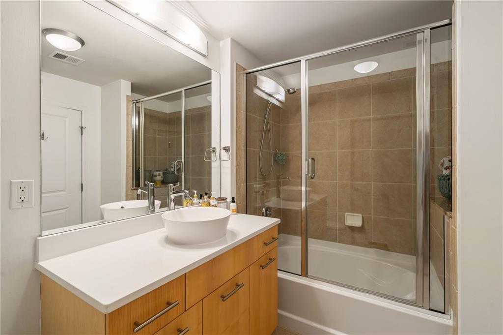 3324 Peachtree Road Northeast, Unit 2705 Atlanta, GA 30326 - Photo 36 of 68 a bathroom with a shower sink vanity and tub