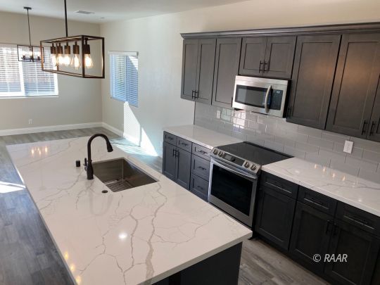 1034 Ocean Avenue Ridgecrest, CA 93555 - Photo 7 of 30 a kitchen with stainless steel appliances granite countertop a sink a stove a microwave and island