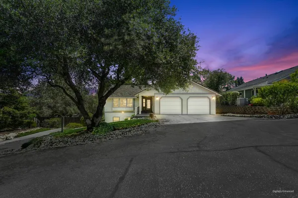 a front view of a house with a yard and trees