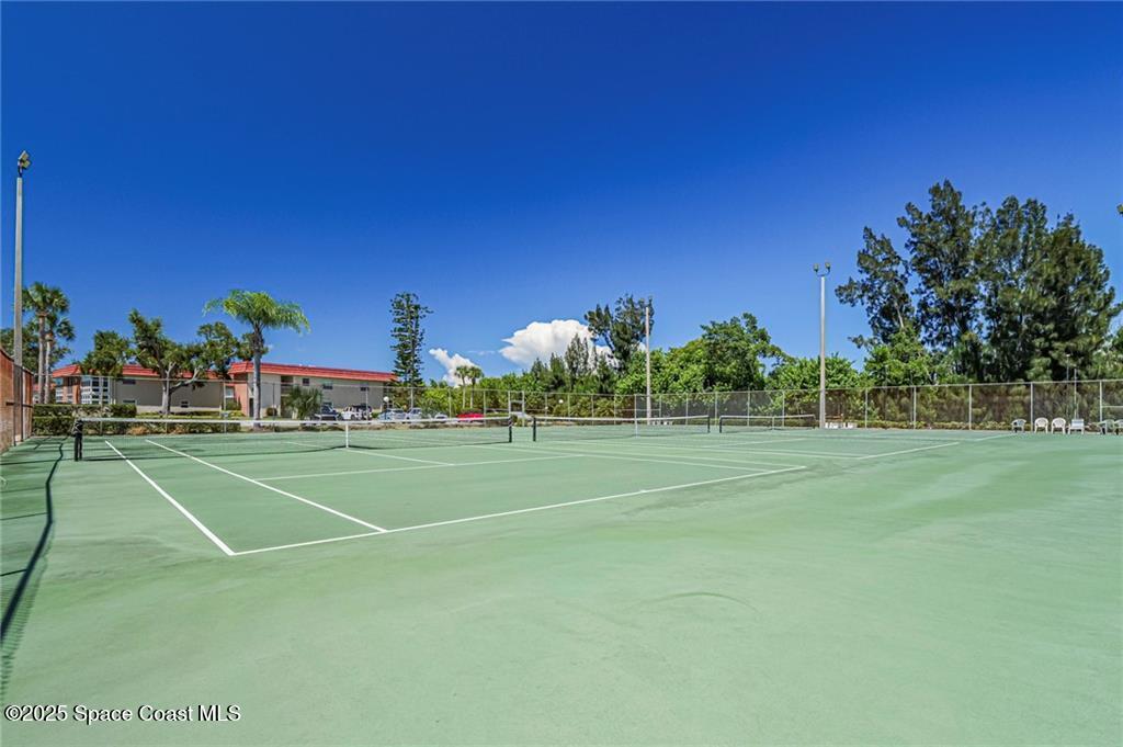 25 Pine Arbor Lane, Unit 104 Vero Beach, FL 32962 - Photo 26 of 34 a view of a tennis ground with large trees