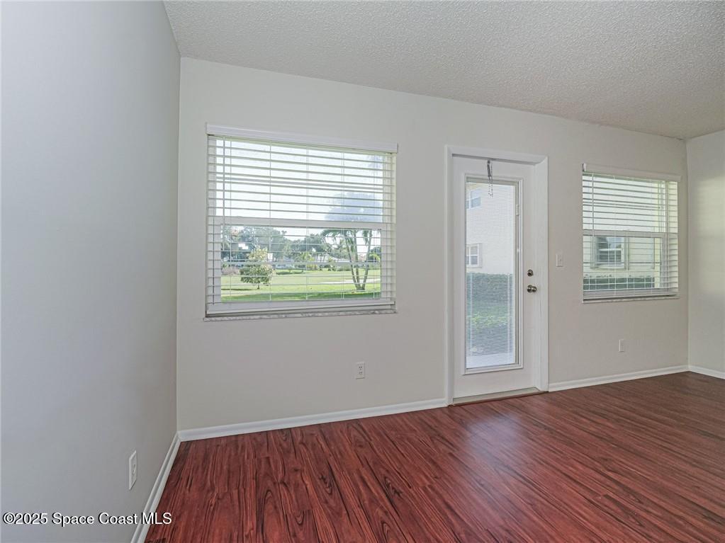 25 Pine Arbor Lane, Unit 104 Vero Beach, FL 32962 - Photo 6 of 34 an empty room with wooden floor and windows