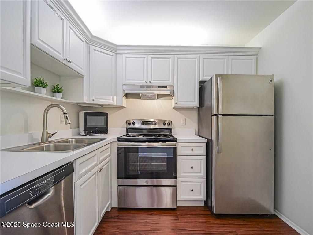 25 Pine Arbor Lane, Unit 104 Vero Beach, FL 32962 - Photo 8 of 34 a kitchen with a refrigerator sink and cabinets