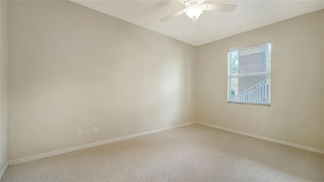 a view of a building next to a big yard and large trees