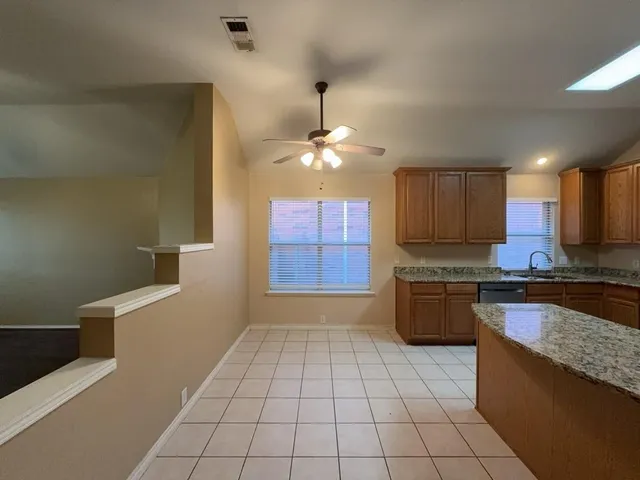 a large kitchen with granite countertop a stove a sink and a microwave