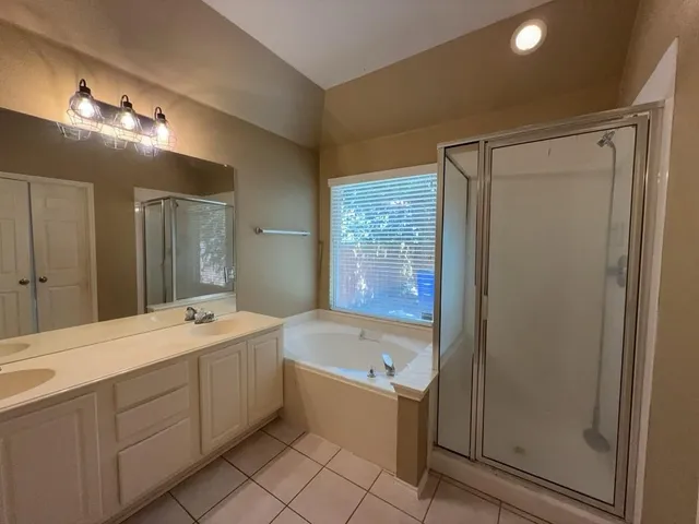 a bathroom with a tub sink shower and mirror
