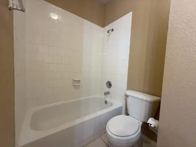 a white toilet and tub sitting next to a bathroom sink