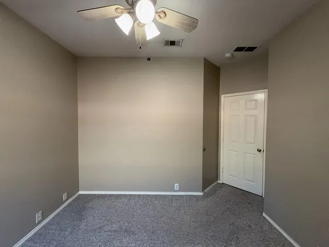 an empty room with a chandelier fan