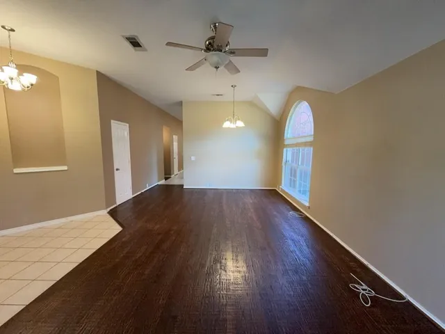 a view of a room with wooden floor and a ceiling fan