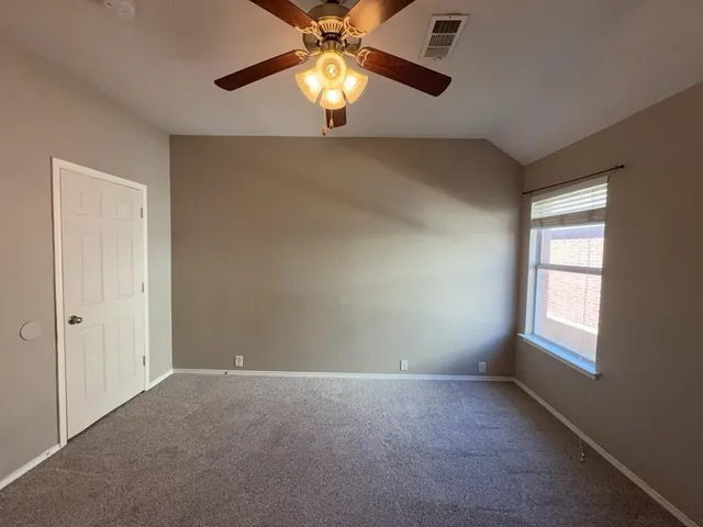 an empty room with windows and fan
