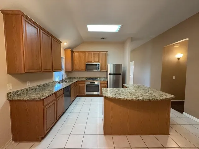 a kitchen with stainless steel appliances granite countertop wooden cabinets a sink and dishwasher