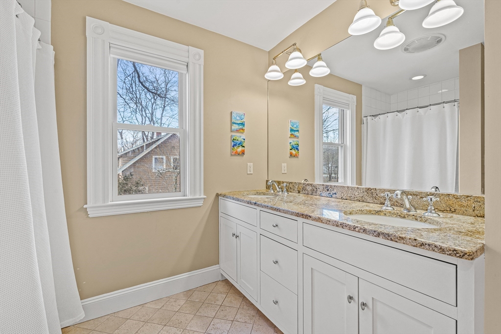 7 Water Street Natick, MA 01760 - Photo 14 of 26 a bathroom with a granite countertop sink a large mirror and a shower