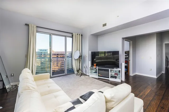 a living room with furniture a flat screen tv and a large window