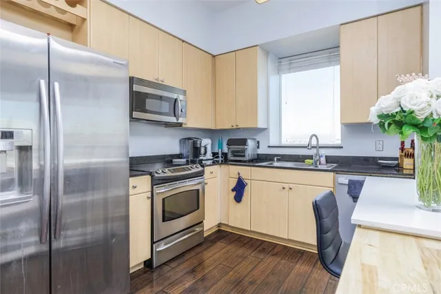 a kitchen with stainless steel appliances granite countertop a stove a sink and a refrigerator