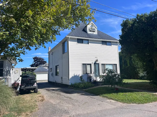 a view of a house with a yard and potted plants