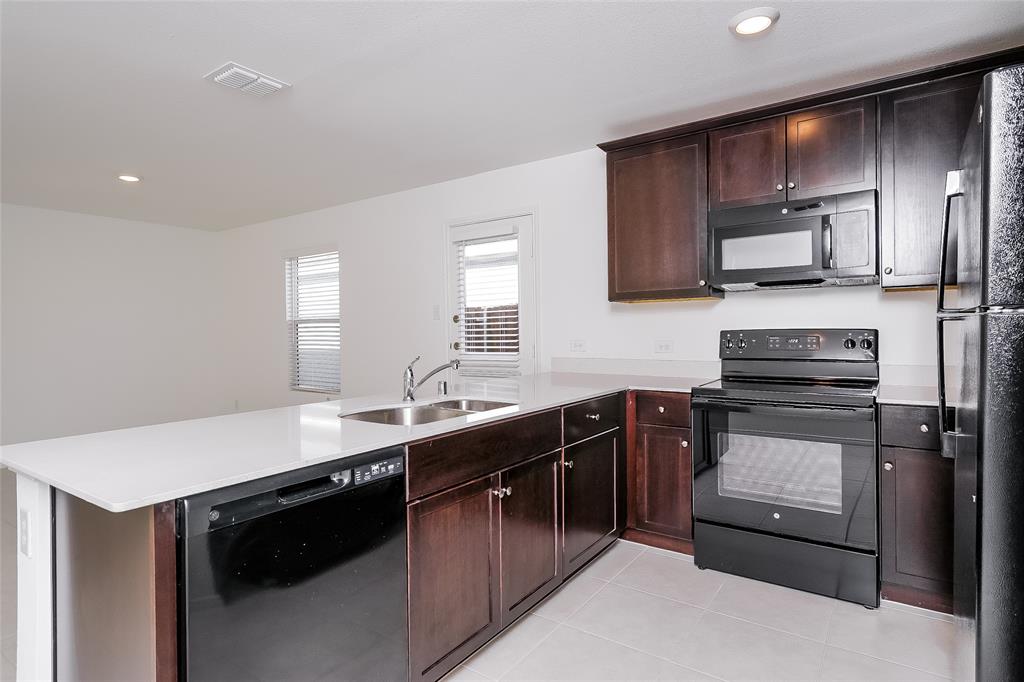 5641 Rockrose Lane Princeton, TX 75407 - Photo 12 of 16 a kitchen with a sink stove and microwave