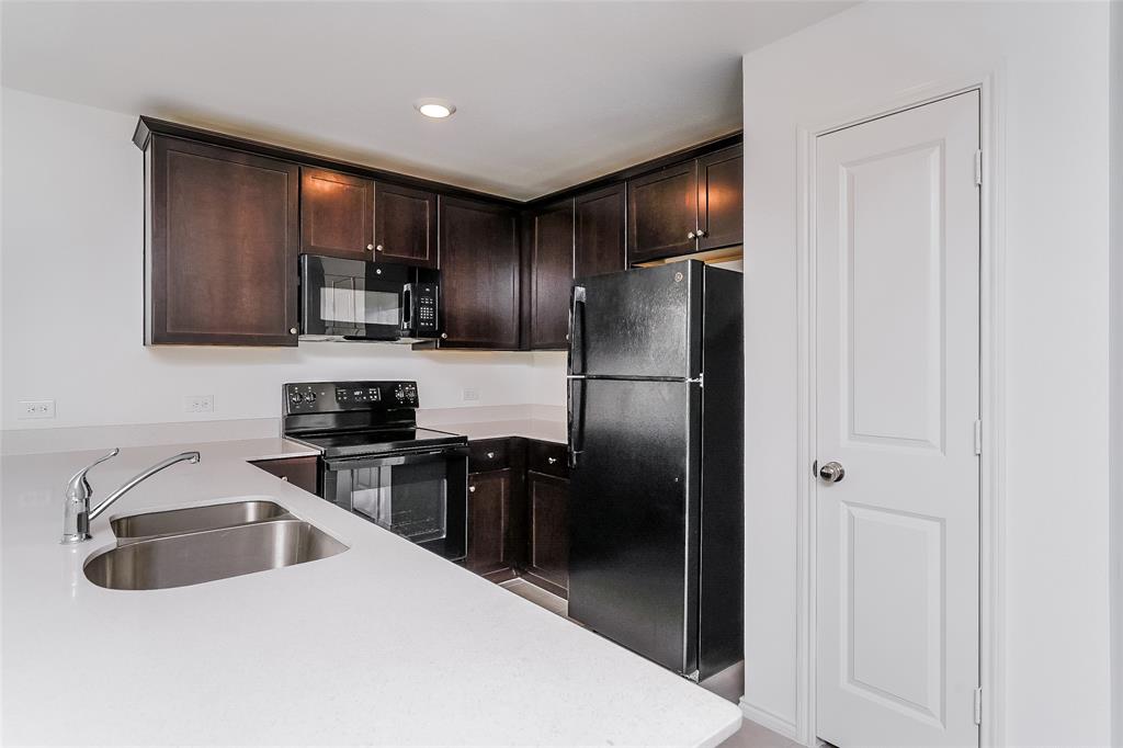 5641 Rockrose Lane Princeton, TX 75407 - Photo 13 of 16 a kitchen with stainless steel appliances a refrigerator a sink a stove a microwave and island