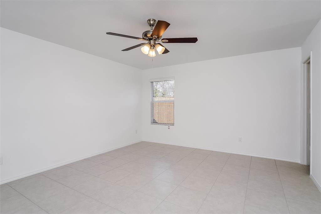 5641 Rockrose Lane Princeton, TX 75407 - Photo 8 of 16 an empty room with chandelier fan and windows