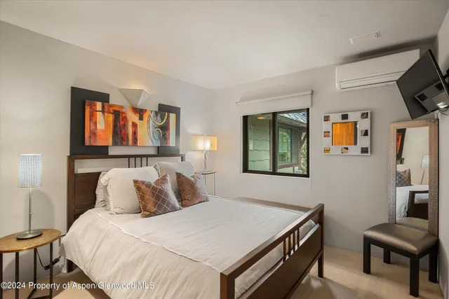 a bedroom with a bed and a flat screen tv