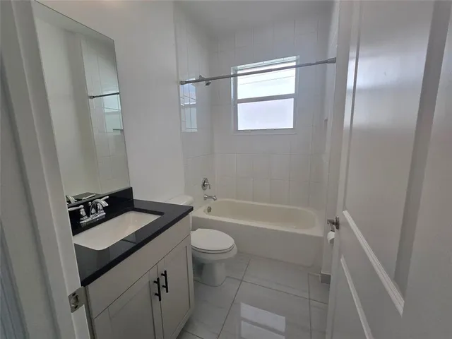 a bathroom with a granite countertop sink toilet a bathtub and shower