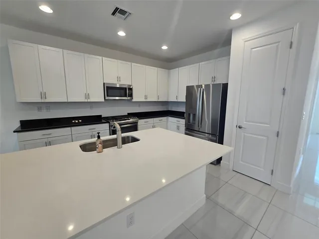 a kitchen with stainless steel appliances a refrigerator sink and cabinets